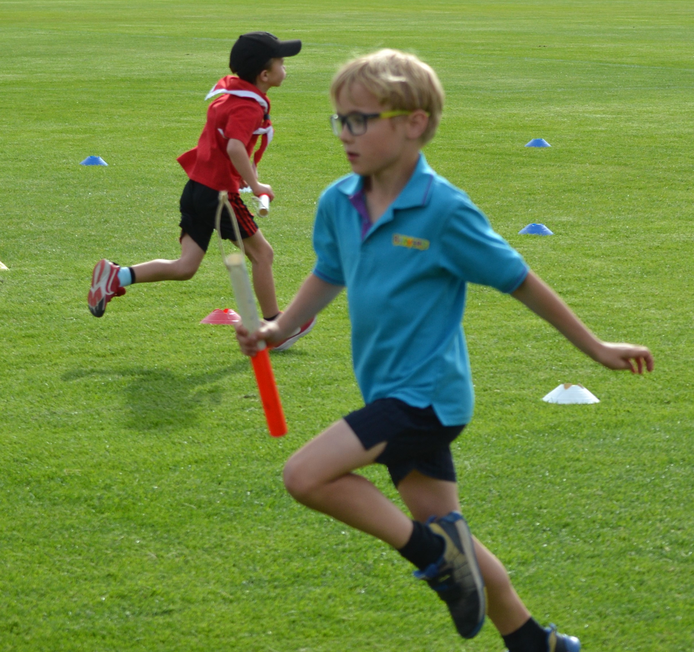 2 Beaver Scouts running opposite directions in a relay race