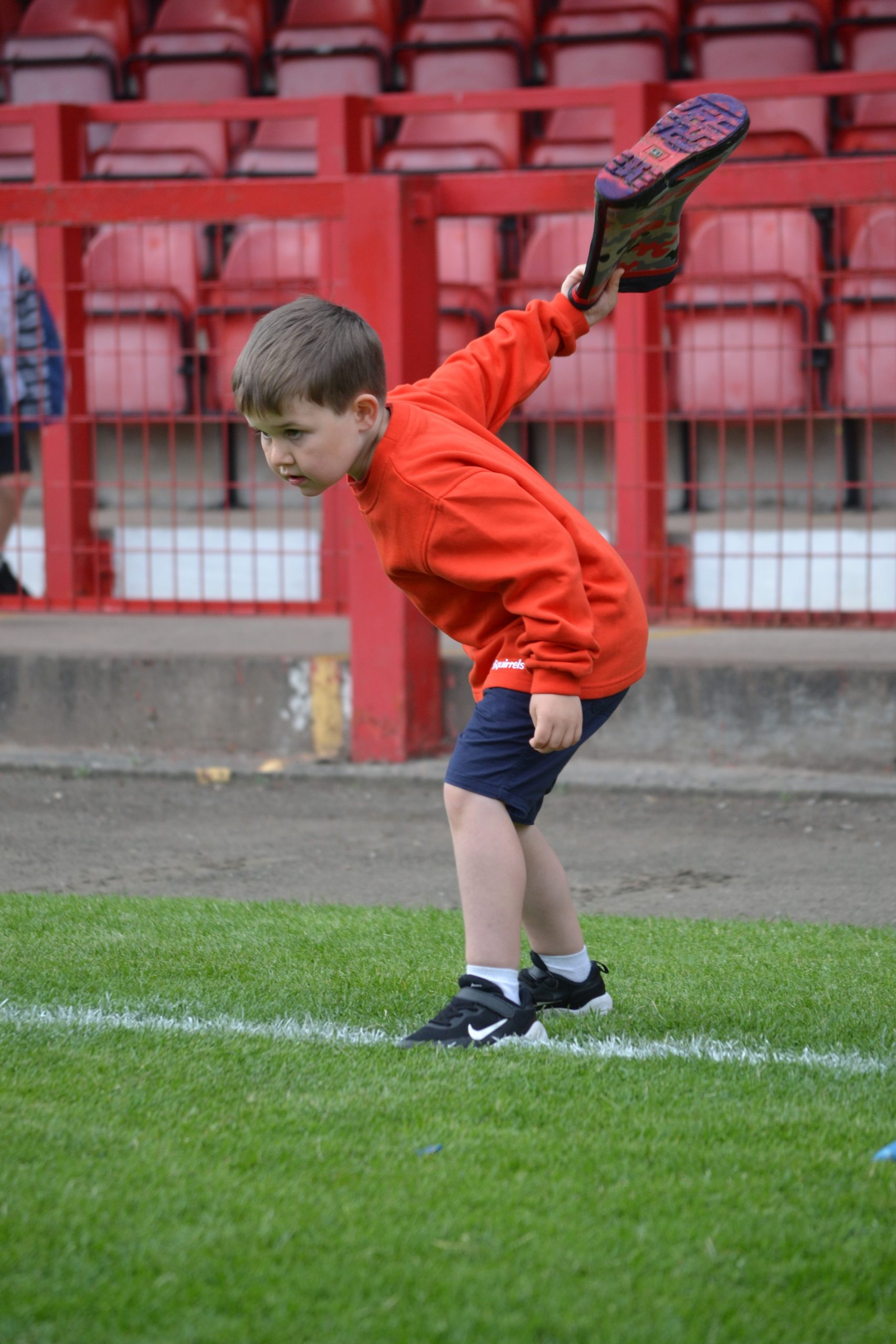 Squirrel Scout swinging to throw a wellington boot